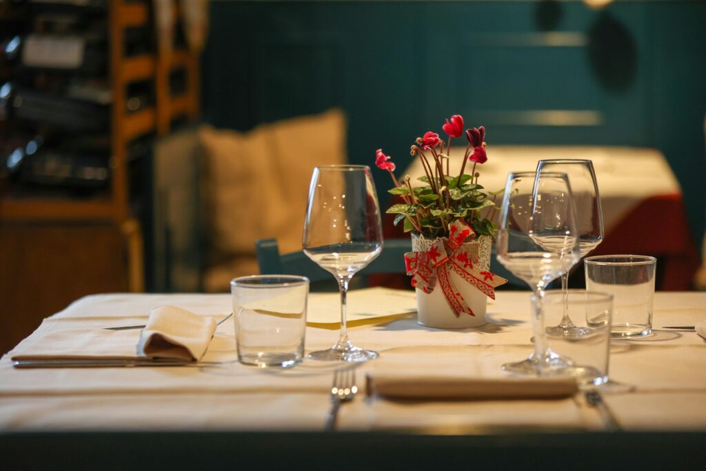 Elegant table setting in a Venetian-style space with glassware, folded napkins, and a floral centerpiece—just like you'd find in the best romantic restaurants in Kochi.