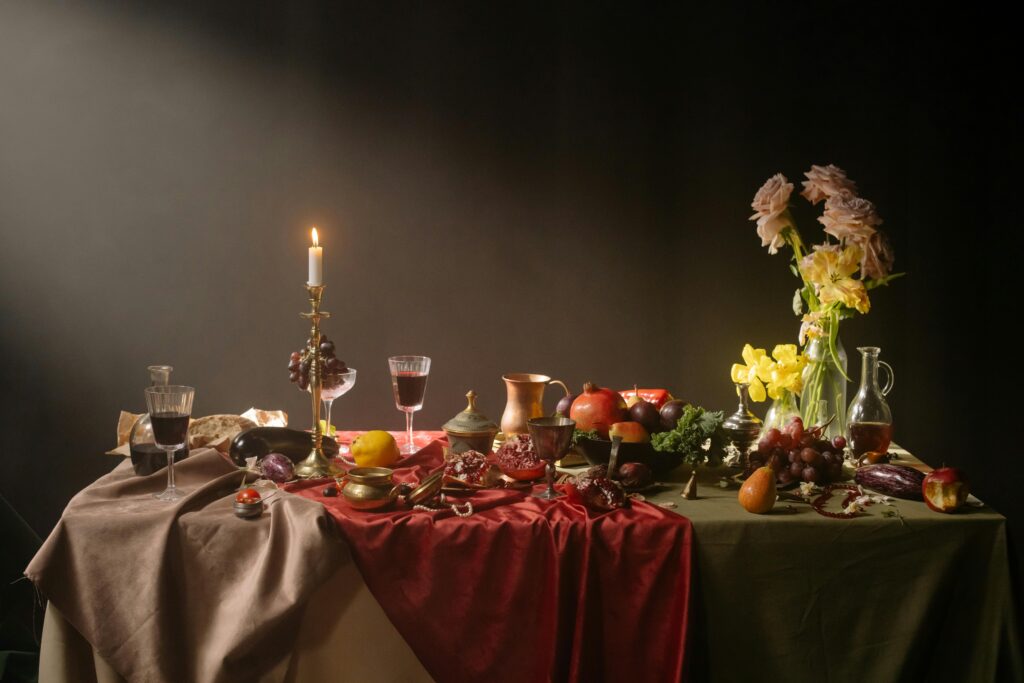 Luxurious candlelit dinner table with fruits, red wine, and flowers creating a warm ambiance.