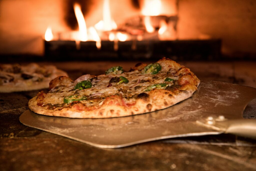 Appetizing gourmet pizza cooked in a wood-fired oven, showcasing artisanal toppings—a must-try for anyone craving authentic Italian food in Kochi.